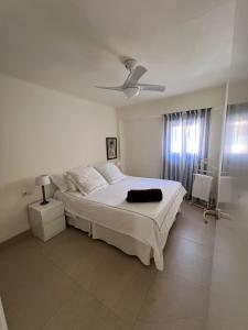 a white bedroom with a bed and a ceiling fan at Precioso apartamento de 2 habitaciones recién reformado en Benidorm in Benidorm