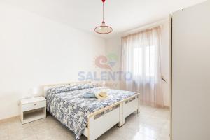 une chambre blanche avec un lit et une fenêtre dans l'établissement Salento and more - Appartamento Grecale Piano Terra, à Torre Pali