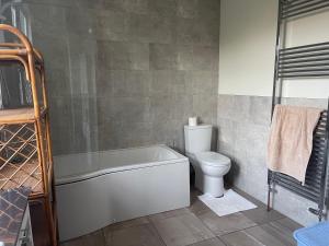 a bathroom with a bath tub and a toilet at The Retreat in Paignton