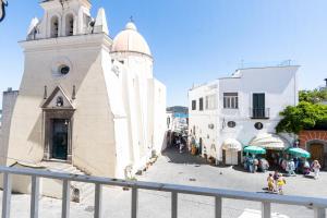 a building with a clock tower next to a street at La Dolce Vita By Fantasy in Forio d'Ischia
