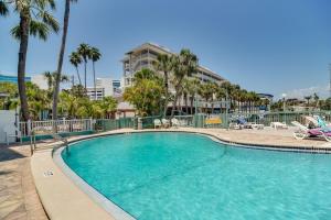 a swimming pool with palm trees in a resort at Condo Across From Clearwater Beach Boardwalk in Clearwater Beach