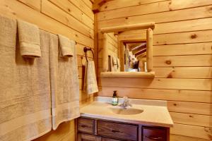 baño con lavabo y espejo en una cabaña de madera en 1 Mi to Current River Cozy Studio Cabin!, en Van Buren