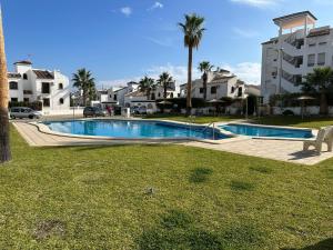 a swimming pool in front of a apartment building at Casa Muchomas - Villamartín in Orihuela Costa