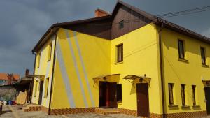 a large yellow building with a black roof at Hotel in Kraslava in Krāslava