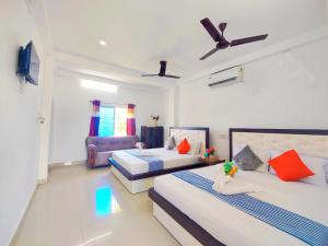 a bedroom with two beds and a chair in it at Jo'stel Hotel Tufan - Sundarban in Purbbadulki +42 photos