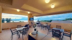 a restaurant with tables and chairs and large windows at Jovis Domus in Eforie Sud
