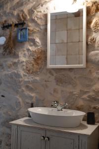 ein Badezimmer mit einem Waschbecken und einem Spiegel an einer Steinwand in der Unterkunft Hello Sunshine in Veli Iž + 38 Fotos