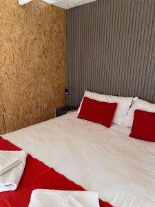 a bedroom with a large white bed with red pillows at La Misión Tiny Houses in Ciudad Lujan de Cuyo