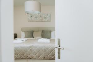 エメッテンにあるFeel Home Apartments 901 - Seesicht- Bergsicht - Parkplatzのベッドルーム1室(白いベッドカバー付)