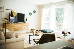 エメッテンにあるFeel Home Apartments 901 - Seesicht- Bergsicht - Parkplatzのソファとテレビのあるリビングルーム