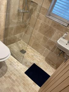 a bathroom with a shower with a toilet and a sink at Cottage of Content in Wivenhoe