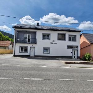 a white building on the side of a street at Vila Natasa Apartment 4 near Plitvice in Vrhovine