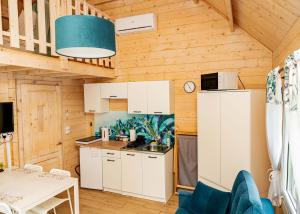 a kitchen with white cabinets and a table at Skrawek Nieba Borsk in Borsk