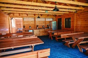 a dining room with wooden tables in a cabin at Wczasy u Juliana in Drewnica