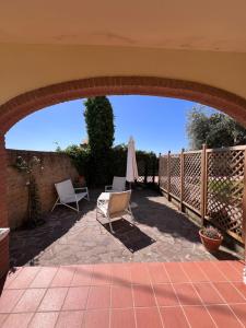 an outdoor patio with two chairs and an umbrella at Villa Althea in Piombino