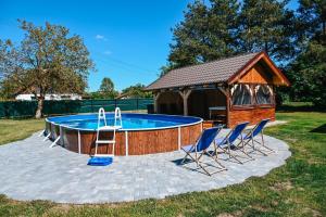 a pool with chairs and a gazebo at Wczasy u Juliana in Drewnica