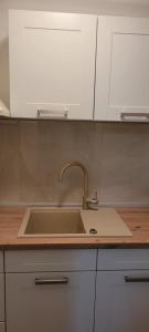 a kitchen counter with a sink and white cabinets at Apartments Matas in Rogoznica