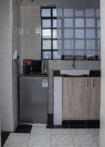 a kitchen with a sink and a refrigerator at Nanyuki Modern 1 Bedroom in Nanyuki