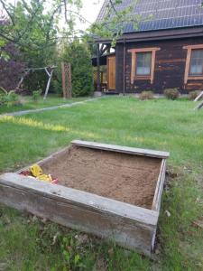 a bed of dirt in a yard in front of a house at Pokoje Gościnne Wojtek-2 in Białowieża +1 photo