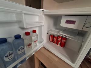 an open refrigerator with bottles of water and soda at La Vie en Rose in Verviers
