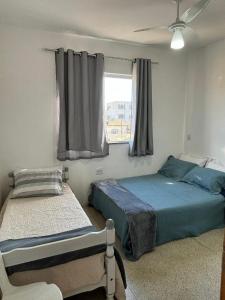 a bedroom with two beds and a window at Conexão Mineira in Pedro Leopoldo