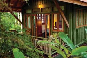 a small green house with a wooden porch at Sunset at the Palms Resort - Adults Only - All Inclusive in Negril