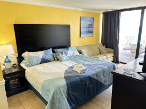 una camera da letto con un letto grande e un divano di The Palms Resort a Myrtle Beach Altre 24 foto
