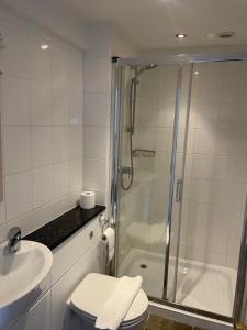 a bathroom with a shower and a toilet and a sink at The Foresters Arms in Carlton