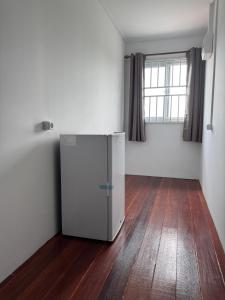 a white refrigerator in a room with a wooden floor at Garnizoenspad appartementen in Baskamp