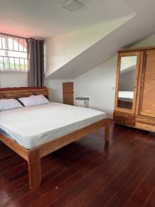 a bedroom with a bed and a dresser and a mirror at Garnizoenspad appartementen in Baskamp