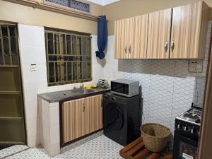 a small kitchen with a sink and a microwave at Urban Corner in Kampala +7 photos