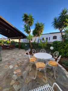 a patio with a table and chairs and palm trees at Amici di Calabria in Scalea