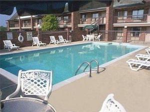 a large swimming pool with chairs and a hotel at Inn of Clanton in Clanton