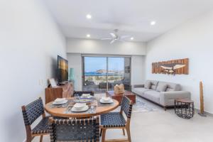 un soggiorno con tavolo, sedie e divano di Danzante Bay Oceanfront 2 BR Beach & Golf a Ensenada Blanca