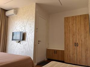 a bedroom with a bed and a television on a wall at saba-nia in Gonio