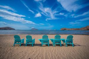 tres sillas y una mesa en la playa en 2BR Summer Escape Villa in Danzante Bay Loreto, en Ensenada Blanca