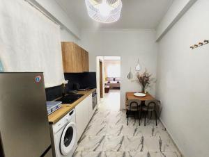 eine Küche mit einem kleinen Tisch und eine Küche mit einem Kühlschrank in der Unterkunft Lux Suite Jacuzzi Acropolis byMK in Athen