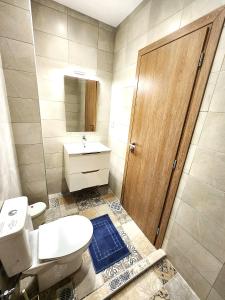 ein Badezimmer mit Toilette und Waschbecken und einer Holztür in der Unterkunft Lux Suite Jacuzzi Acropolis byMK in Athen + 10 Fotos