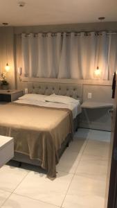 a bedroom with a large bed with two lights on it at Paradise Beach Flat 211 in João Pessoa