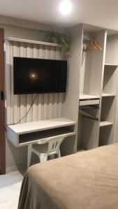a bedroom with a desk with a tv and a bed at Paradise Beach Flat 211 in João Pessoa