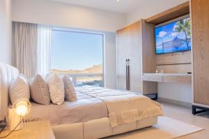 una camera da letto con un letto grande con una grande finestra di Extraordinary Beachfront Danzante Bay Loreto a Ensenada Blanca