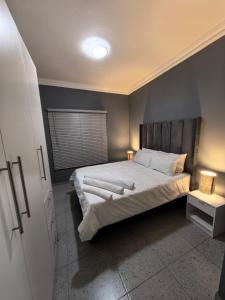 a bedroom with a large bed with white sheets at Selina Guesthouse in Kempton Park
