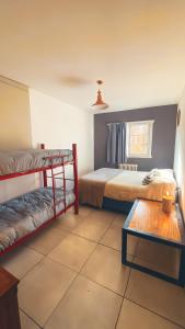 a bedroom with two bunk beds and a table at Hostel Like Quijote in San Carlos de Bariloche