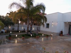 a building with palm trees and candles in a courtyard at Mare&Relax in Mazara del Vallo