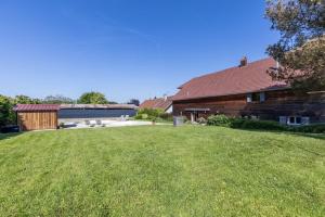 une grange avec une cour herbeuse à côté d'un bâtiment dans l'établissement Domaine Chez Feldus, à Villers-Farlay 20 autres photos