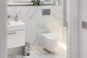 a white bathroom with a toilet and a sink at Pet-friendly apt in Shenfield in Shenfield