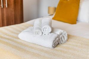 a pile of towels sitting on top of a bed at Pet-friendly apt in Shenfield in Shenfield