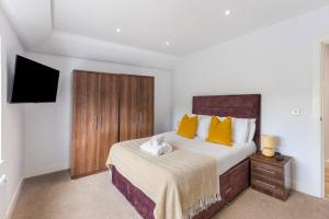 ShenfieldにあるPet-friendly apt in Shenfieldのベッドルーム(黄色い枕のベッド1台、テレビ付) +10枚の写真
