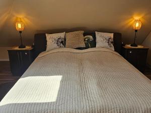 a bedroom with a large bed with two lamps at Hétvezér Penthouse Apartments in Szeged