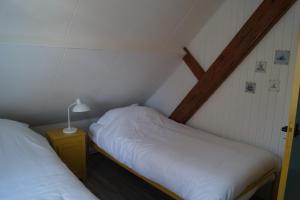 two twin beds in a room with a roof at Vakantiehuis 't Boerenhuis in Aagtekerke